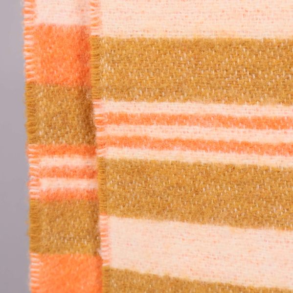 Närbild på ränder i orange, beige och olivgrönt