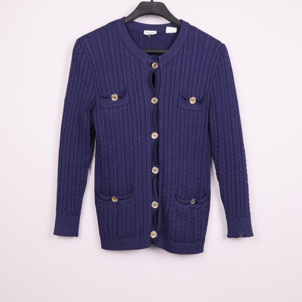 Blå kabelstickad cardigan med guldknappar på galge framifrån