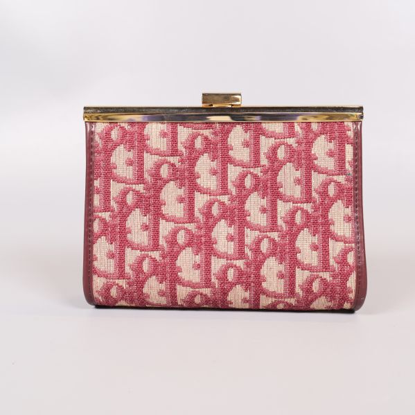 Baksidan av clutch med tätt monogrammönster i rött och beige