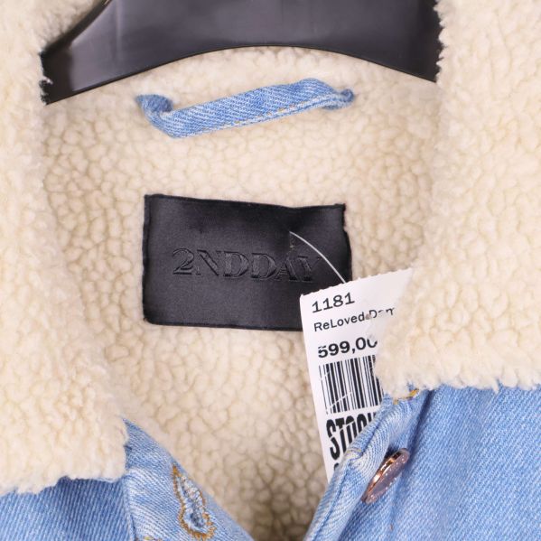 Sido- och ärmdetalj på jeansjackan med knappslå