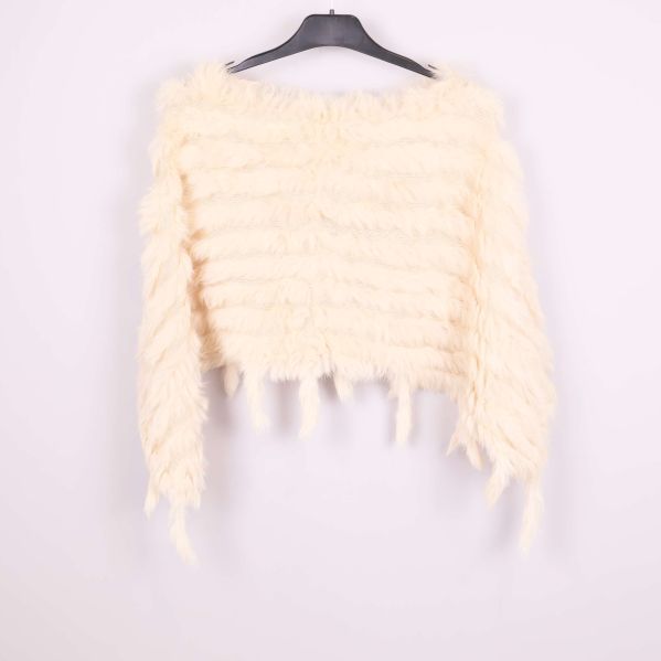 Krämvit poncho bakifrån med fluffig struktur och fransar