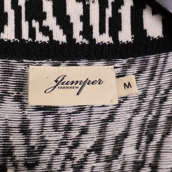 Närbild på etikett med Jumperfabriken och storlek M