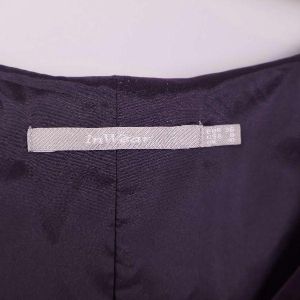 Närbild på InWear-loggan i klänningens nacke