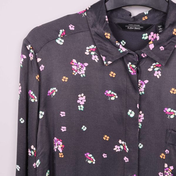 Närbild på skjortans krage och blommigt mönster