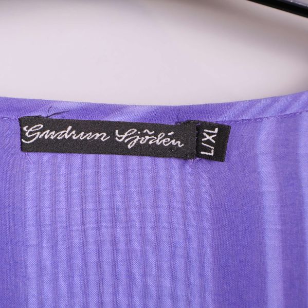 Närbild på Gudrun Sjödén-etikett och storlek L/XL