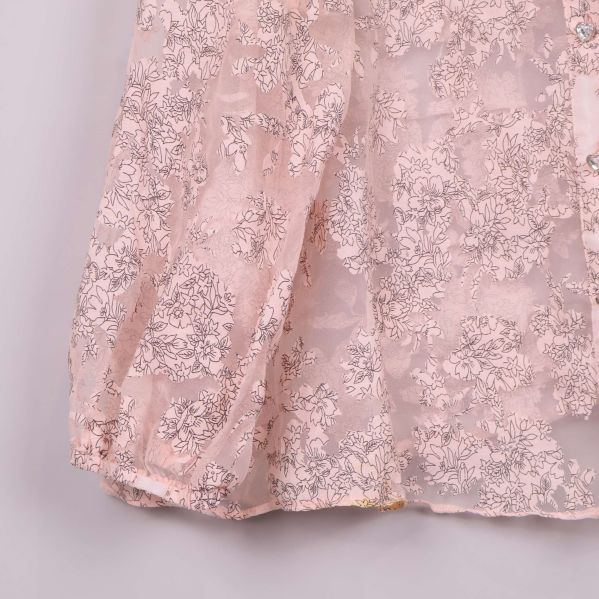 Närbild på ärmslut på blommig transparent blus
