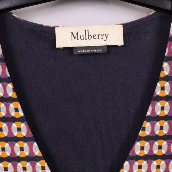 Närbild på Mulberry-märket och klänningens v-ringning