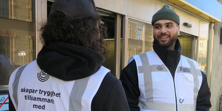 Baba arbetar uppsökande i kollektivtrafiken. Två män pratar med varandra
