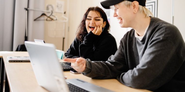 Elever på Stadsmissionens Folkhögskola tittar på en dator.