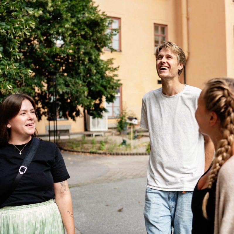 Deltagare på Stockholms Stadsmissions yrkeshögskole-kurser står på skolgården.
