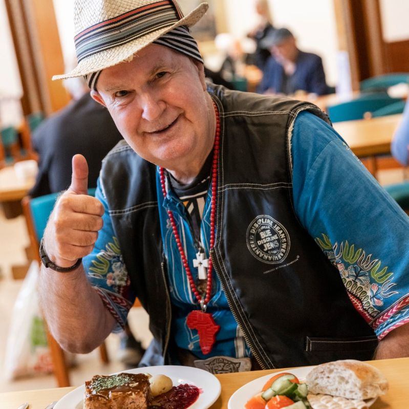 Man som äter mat ger tumme upp.