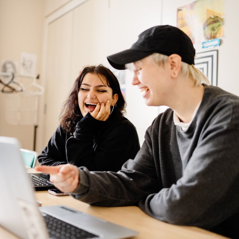 Elever på Stockholms Stadsmissions folkhögskola sitter vid en dator.