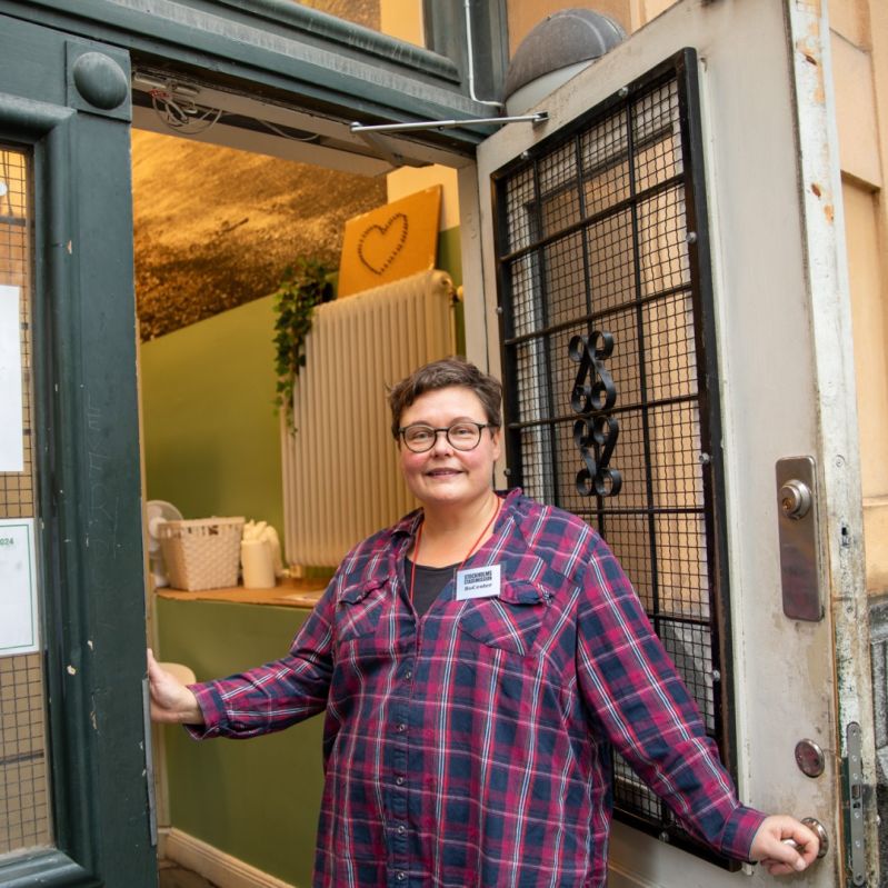 Carolina öppnar dörren till Stockholms Stadsmissions dagverrksamhet för män i hemlöshet.