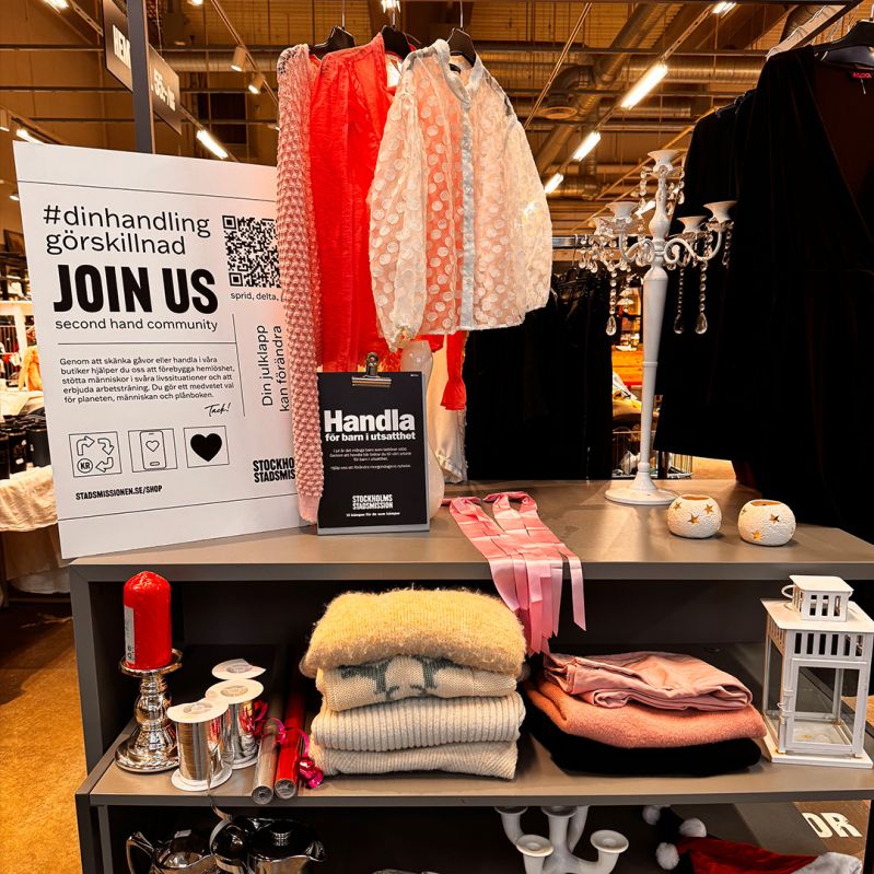 Hylla och hängare med kläder och prylar skyltade