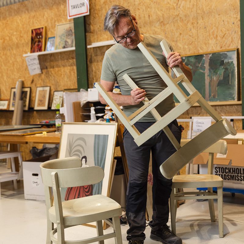 En medarbetare på produktion kollar möbler som skänkts av gåvogivare.