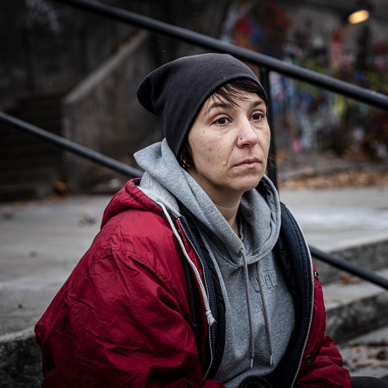 Genrebild där en kvinna sitter i en trapp utan någonstans att ta vägen.