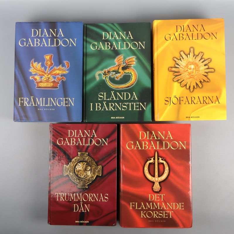 Fem inbundna böcker av Diana Gabaldon med färgstarka omslag