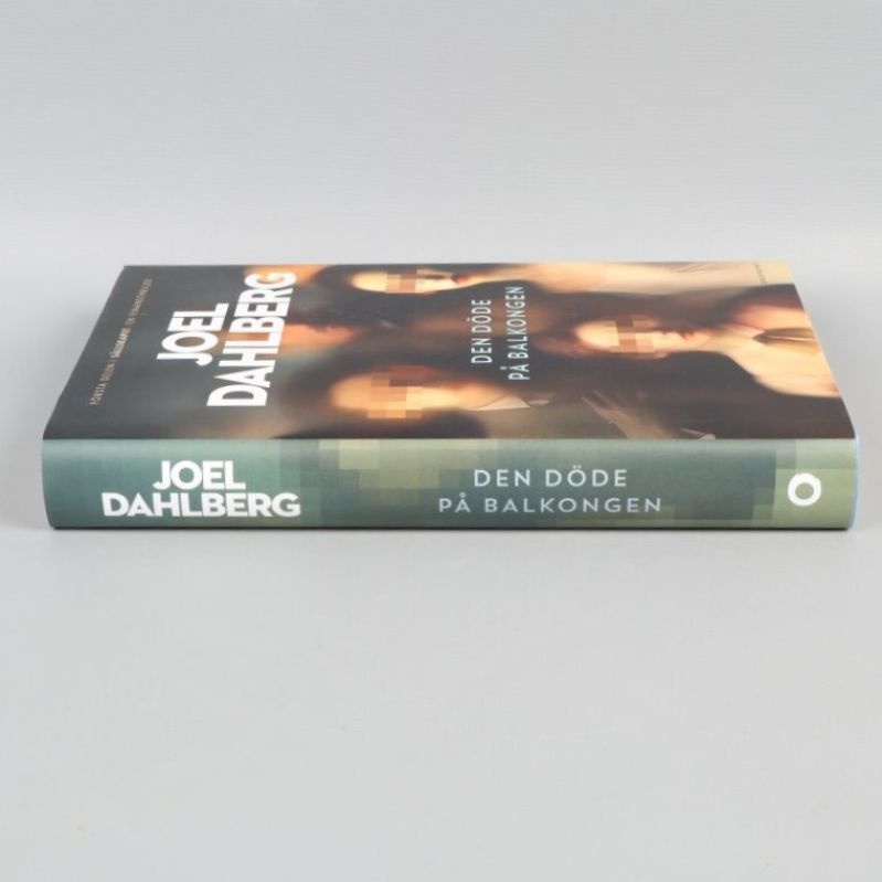 Boken Den döde på balkongen liggande med titel och författare på ryggen