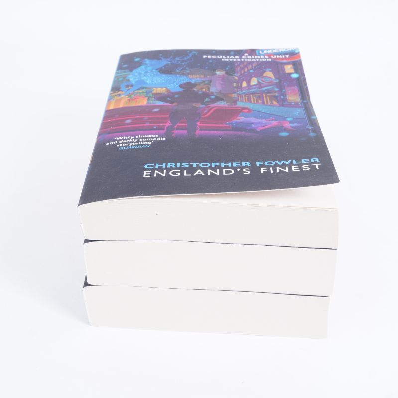 Tre böcker liggande i hög, framsidan av översta boken synlig