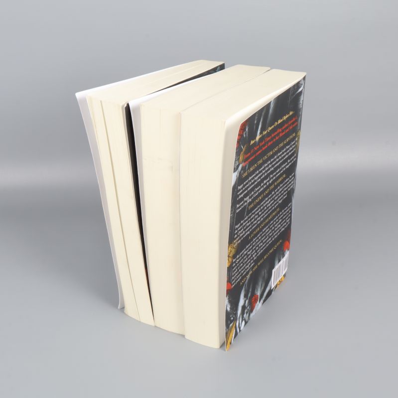 Tre böcker stående på högkant, vinklad vy av bokblocken