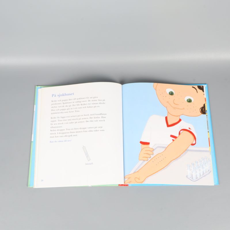 Uppslag ur Kråke-bok med bild på barn i sjukhusmiljö och illustrerade test på armen