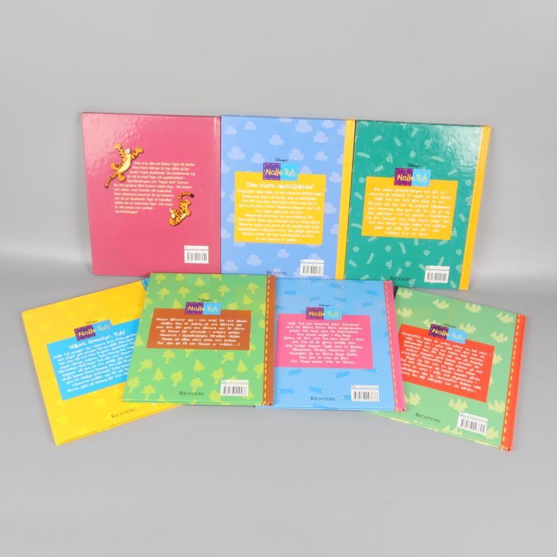 Baksidor av Nalle Puh-böcker med färgstarka textrutor och ISBN