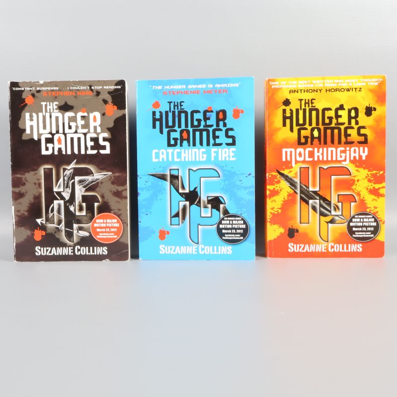 Framsidor på tre Hunger Games-böcker i olika färger