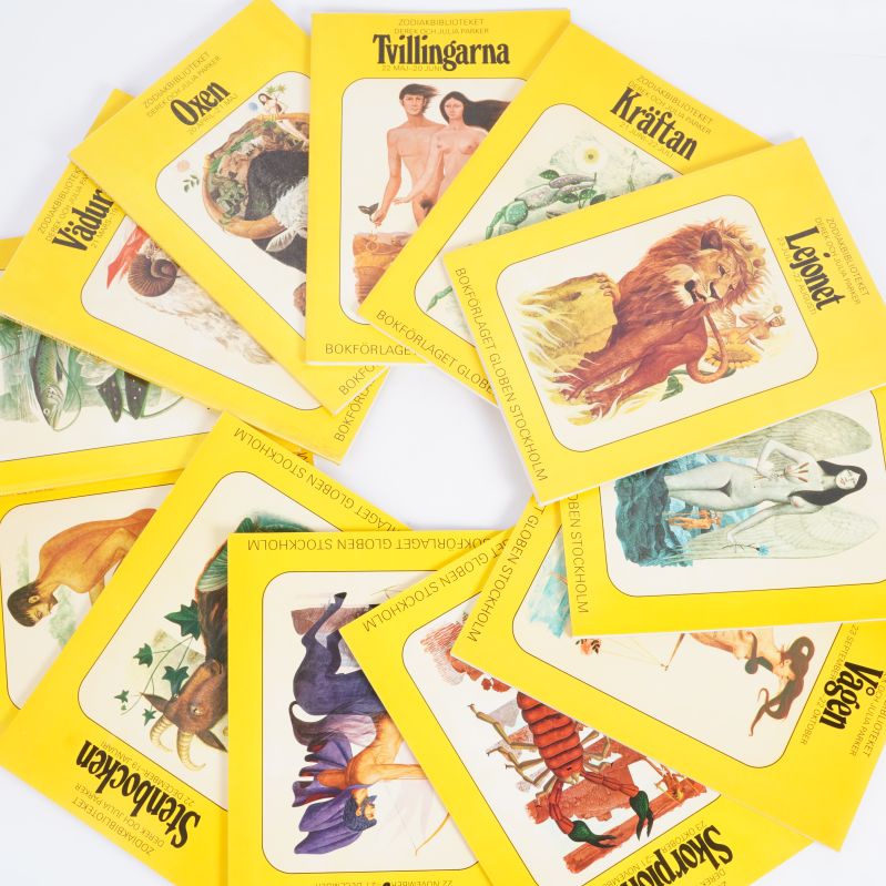 Zodiakböcker utspridda i en cirkel, färgrika omslag syns