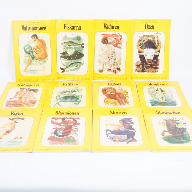 Tolv gula böcker med astrologiska tecken på framsidan