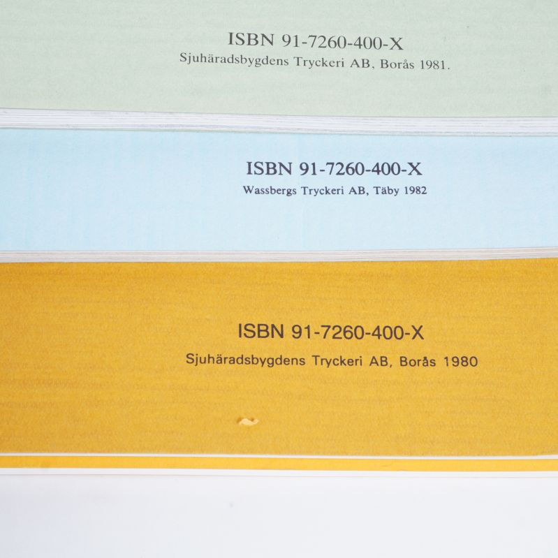 Närbild på tre böckers baksidor med ISBN-nummer tryckta