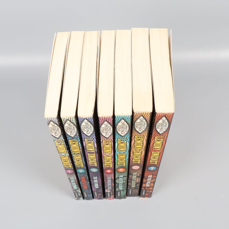 Övre vy av staplade Lemony Snicket-böcker, visar ryggar och toppar