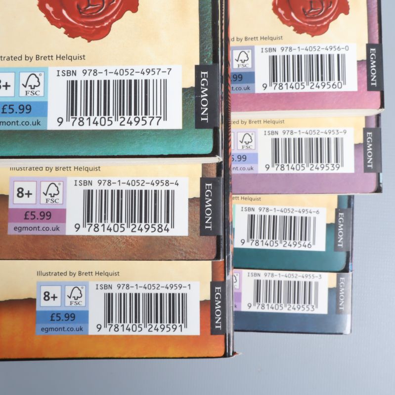 Närbild på ISBN och streckkoder på baksidan av sju böcker