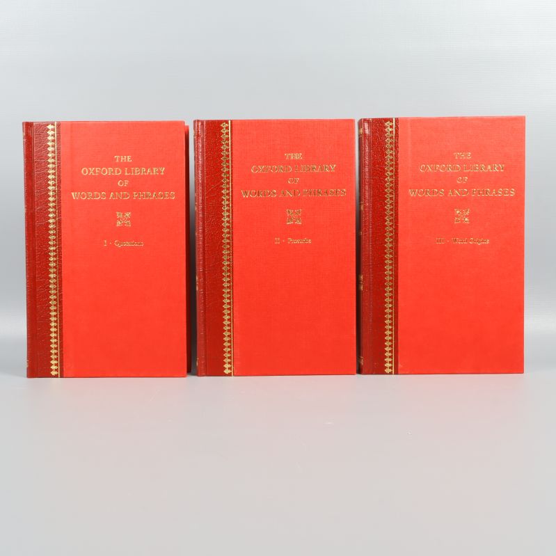 Tre röda volymer uppställda med framsidorna synliga