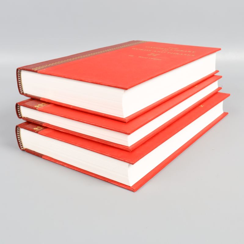 Tre staplade röda böcker med vita sidor
