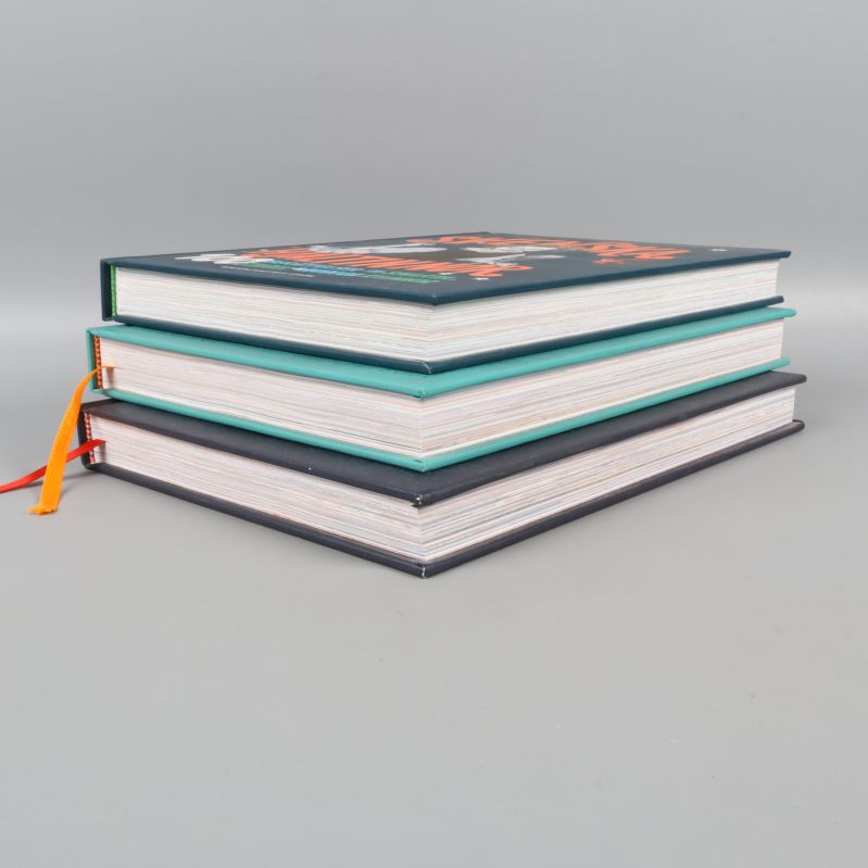 Tre inbundna böcker staplade, synliga sidor