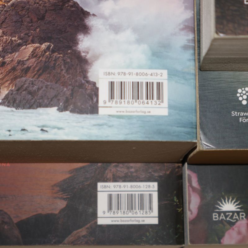 Närbild på ISBN och streckkod på två av böckerna i serien