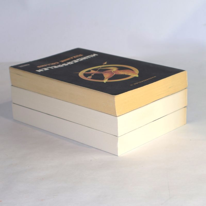 Trave med Hungerspelen-böcker, den översta boken syns med gulnade sidor