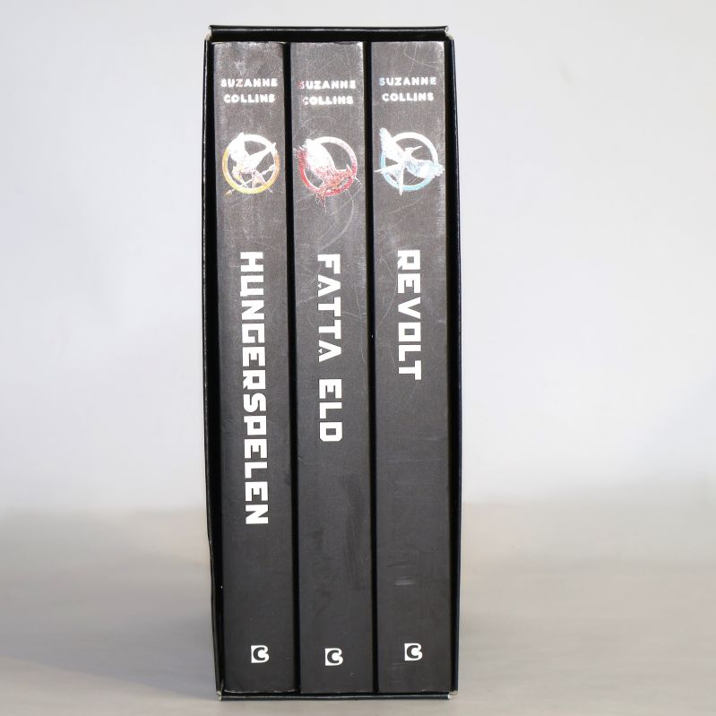 Ryggar på Hungerspelen, Fatta eld och Revolt i box, namn och symboler syns tydligt