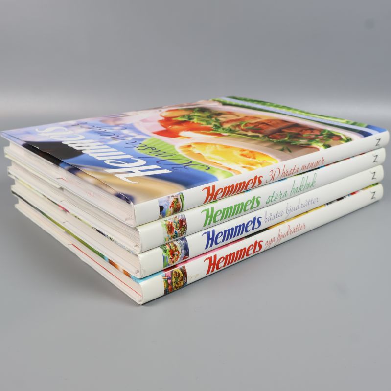 Snett staplade Hemmets kokböcker med tydlig visning av omslag och ryggar