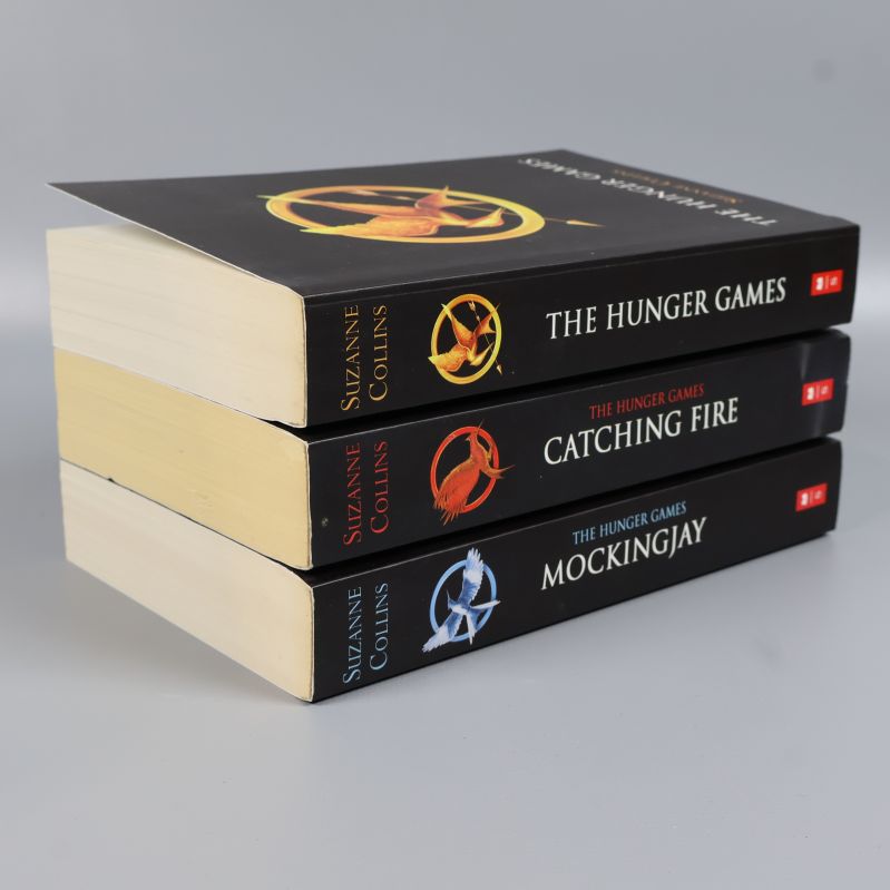 Staplade böcker ur The Hunger Games-serien med synliga sidopartier