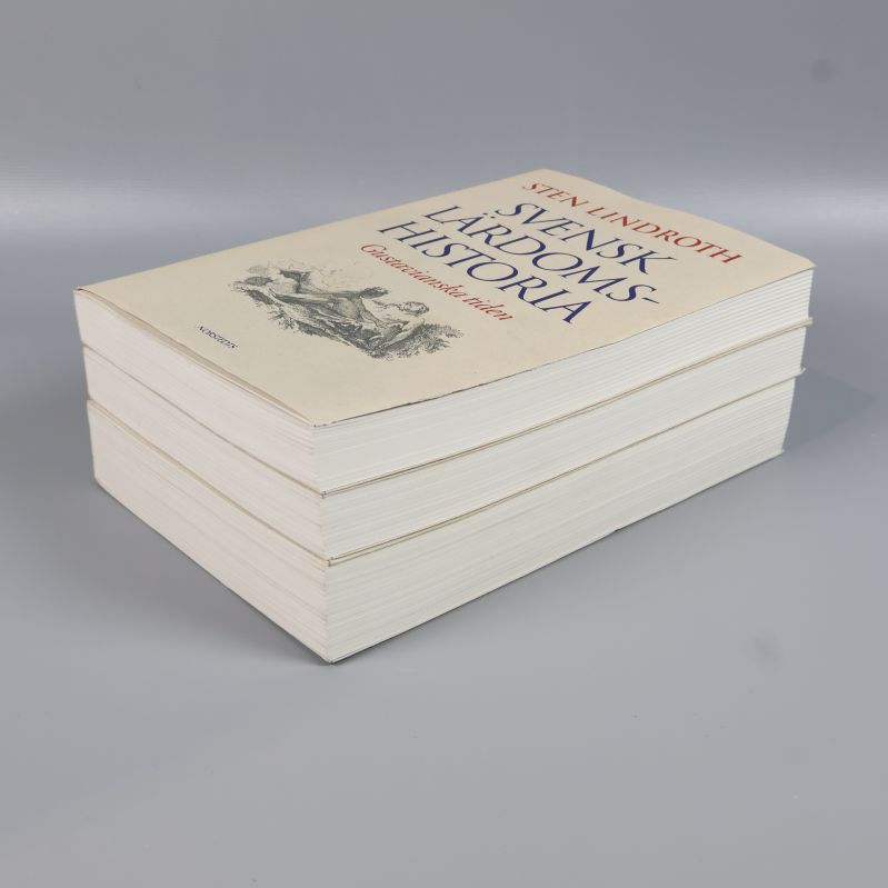 Tre böcker i hög, framsida synlig på översta boken