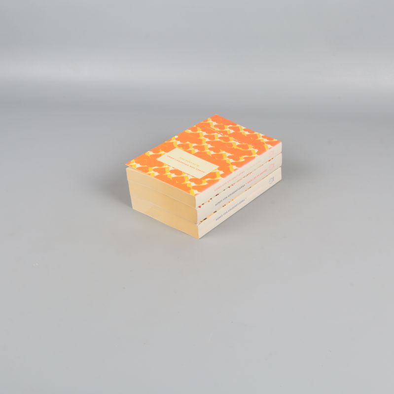 Bokpaket med tre pocketböcker liggande på varandra