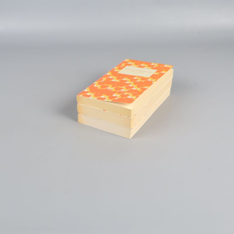 Tre pocketböcker från sidan med synliga färgglada omslag