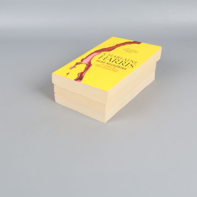 Tre böcker staplade, omslag och sidkanter synliga