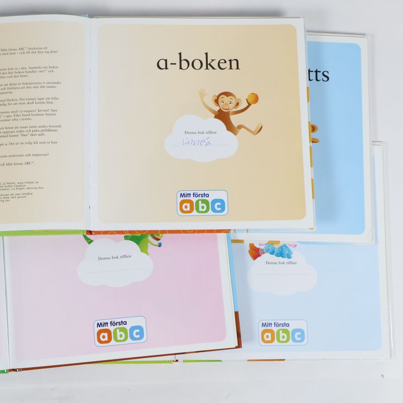 Boksida med a-boken och namn ifyllt i rutan samt fyra böcker till