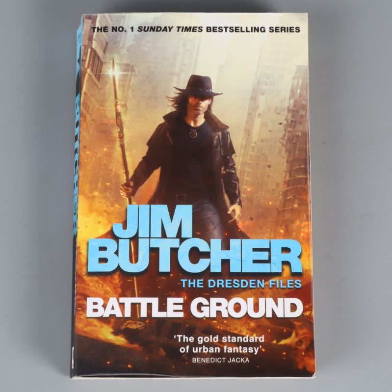 Framsidan på Battle Ground av Jim Butcher med stadssilhuett och huvudperson