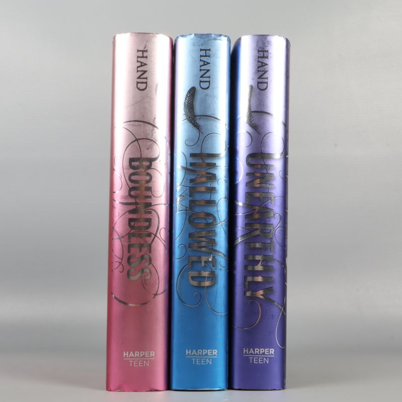 Tre böcker uppradade med orden Boundless, Hallowed, Unearthly på ryggarna