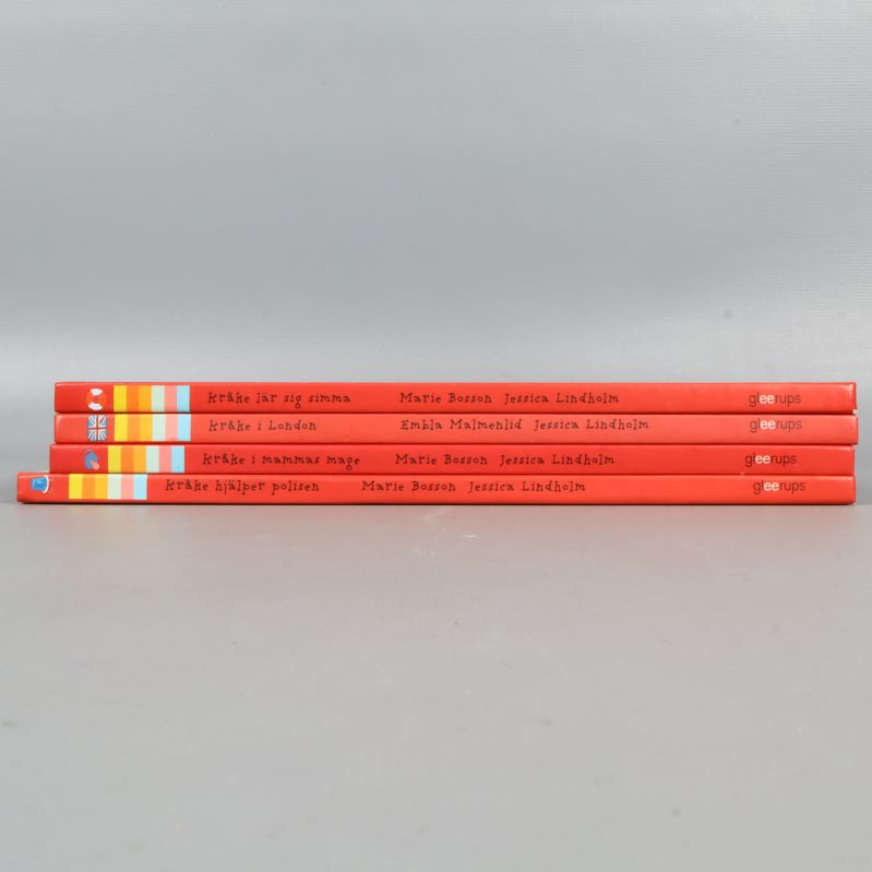 Ryggen av fyra Kråke-böcker i rött och blått