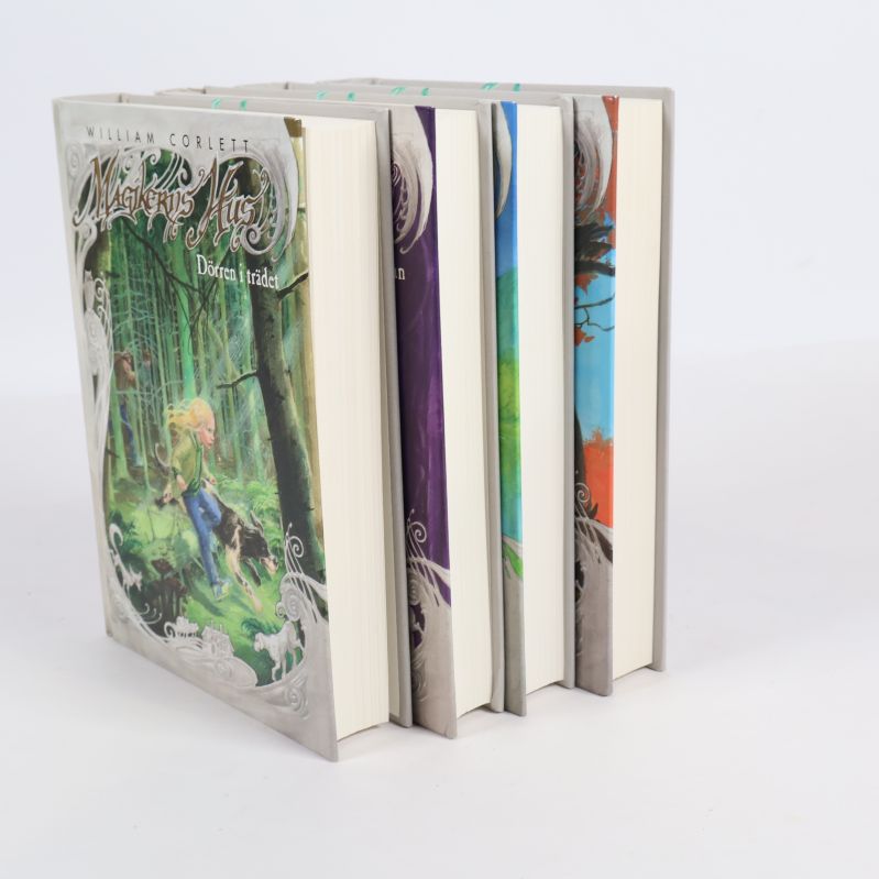 Bokpaket Magikerns hus 1-4 sett snett framifrån, visar bladsidor och omslag