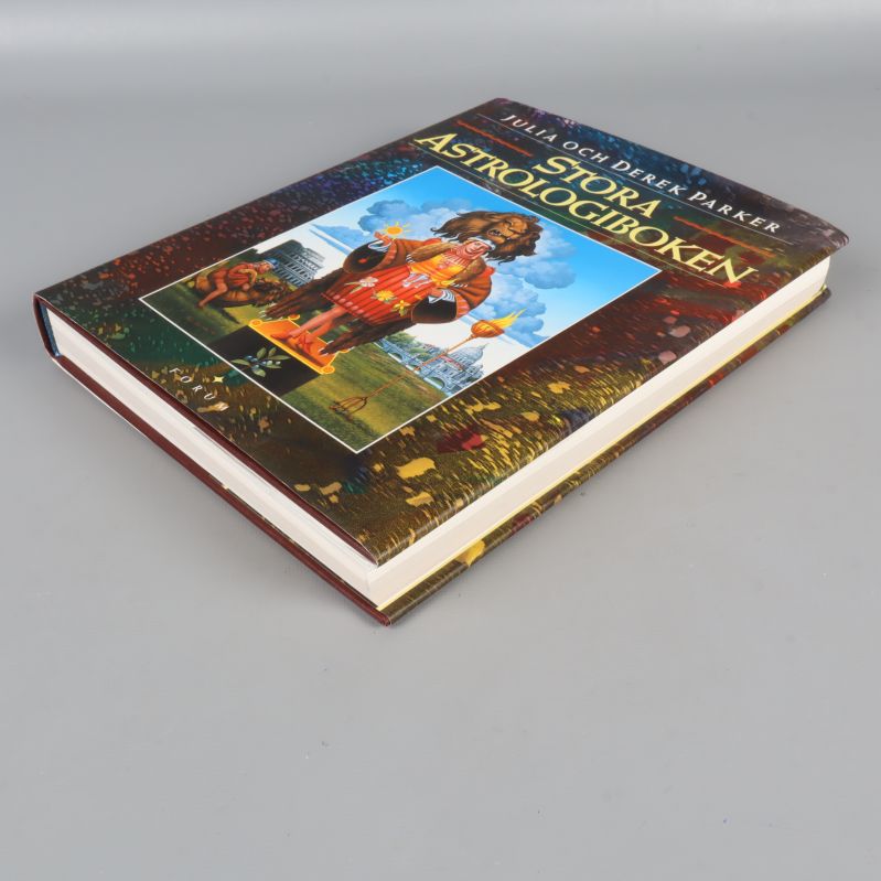 Stora astrologiboken diagonalt framifrån, omslag och sidor synliga